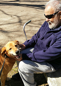 Alzheimer advocate Amy’s dad petting the dog, Layla looks at the camera happily