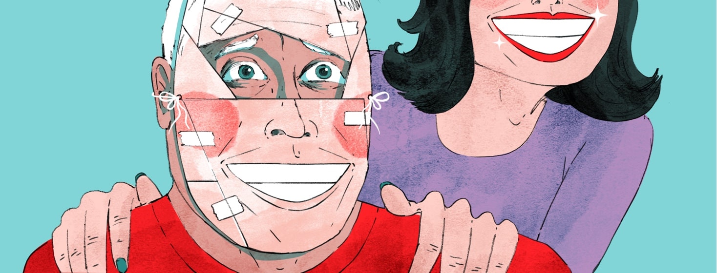 A man wearing a pieced-together mask appears to be grinning because of the mask, but his eyes peering through a space in the mask show him scared and confused. A woman wearing an equally wide grin leans over him with her hands on his shoulders.