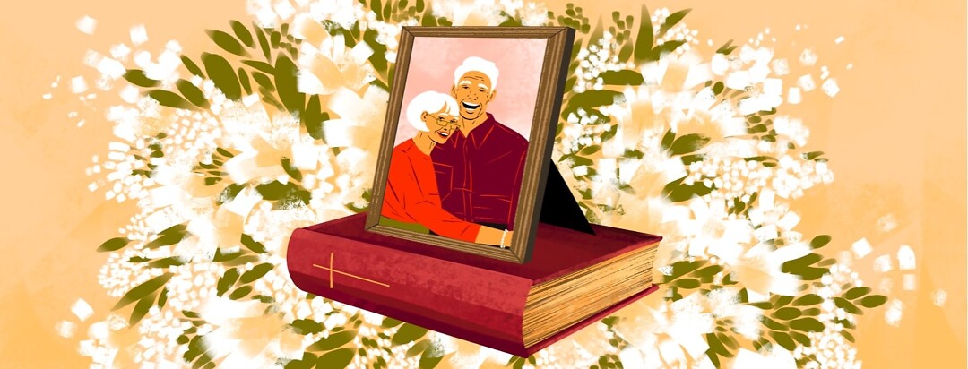 A framed photo of an older couple rests on a worn Bible. The background shows a large display of white flowers.