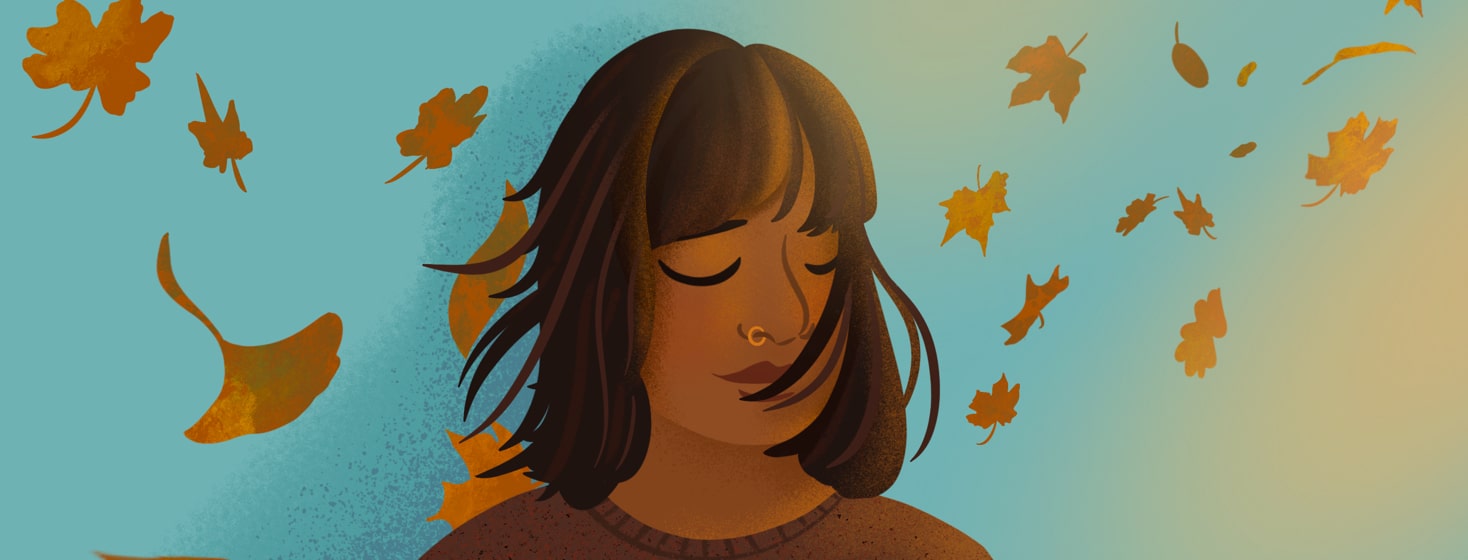 alt=Person closes eyes, managing grief after loss as leaves blow around her.