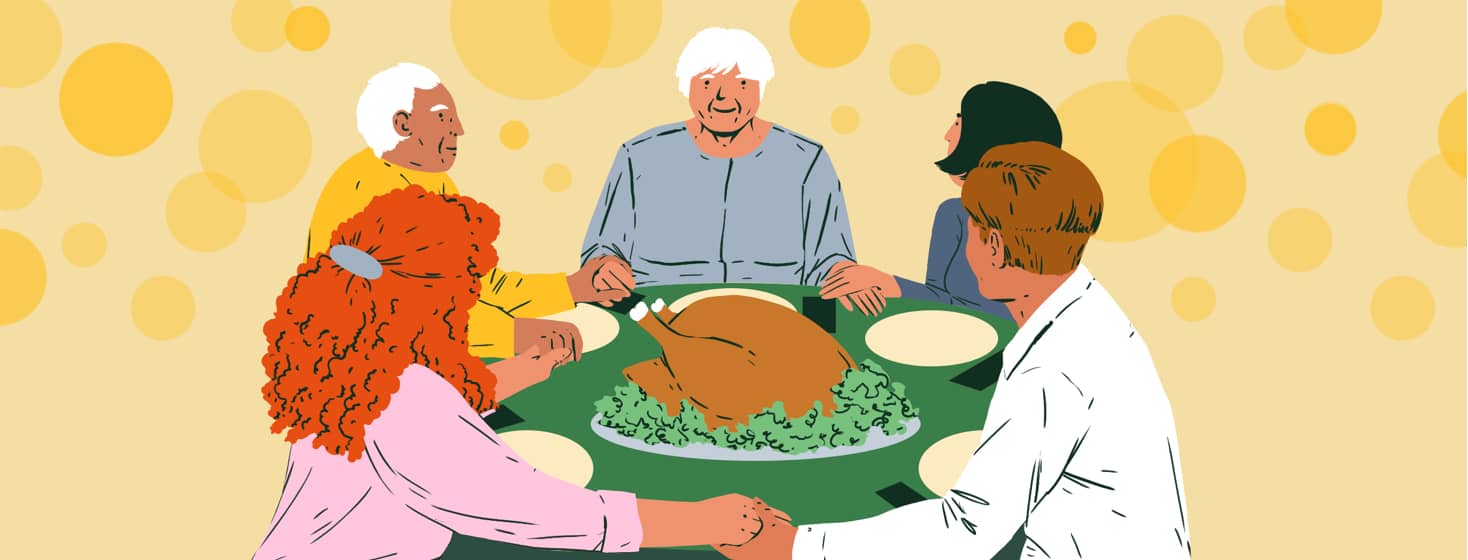 A family smiles and holds hands around a holiday turkey at a table set for dinner