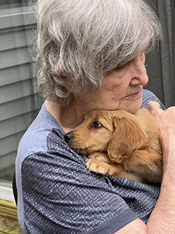 The author's mother hugging a puppy.